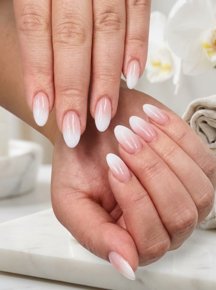 Almond nails with a soft French ombré fading from blush pink to white